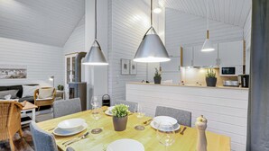 Et moderne køkken med hvide skabe, en træbordplade og en indbygget ovn.