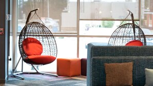 Un interior moderno con lámparas colgantes, una zona de estar con sofá y sillones, y vistas amplias a través de grandes ventanales.