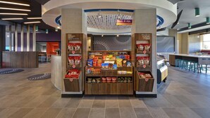 Un petit kiosque proposant divers en-cas emballés et une enseigne faisant de la publicité pour des « boissons et en-cas ».