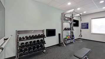 A fitness center with dumbbells, kettlebells, and exercise equipment.