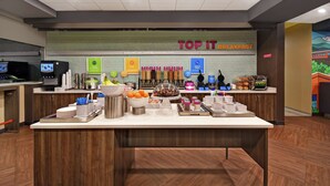 A breakfast buffet area with various food options and a sign that reads "TOP IT BREAKFAST". - Tru By Hilton Burlington (Burlington)