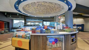 A self-service kiosk with snacks and beverages, a refrigerated display, and a seating area with a view of the outside.