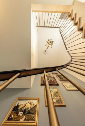 A spiral staircase with a chandelier, framed artwork, and a view of the upper floor. - Fantastic view of the old town of Ochsenfurt (Ochsenfurt)