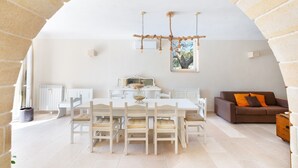 Une pièce spacieuse avec un haut plafond en arc de cercle, une table à manger avec des chaises, un canapé marron et une fenêtre offrant une vue agréable.