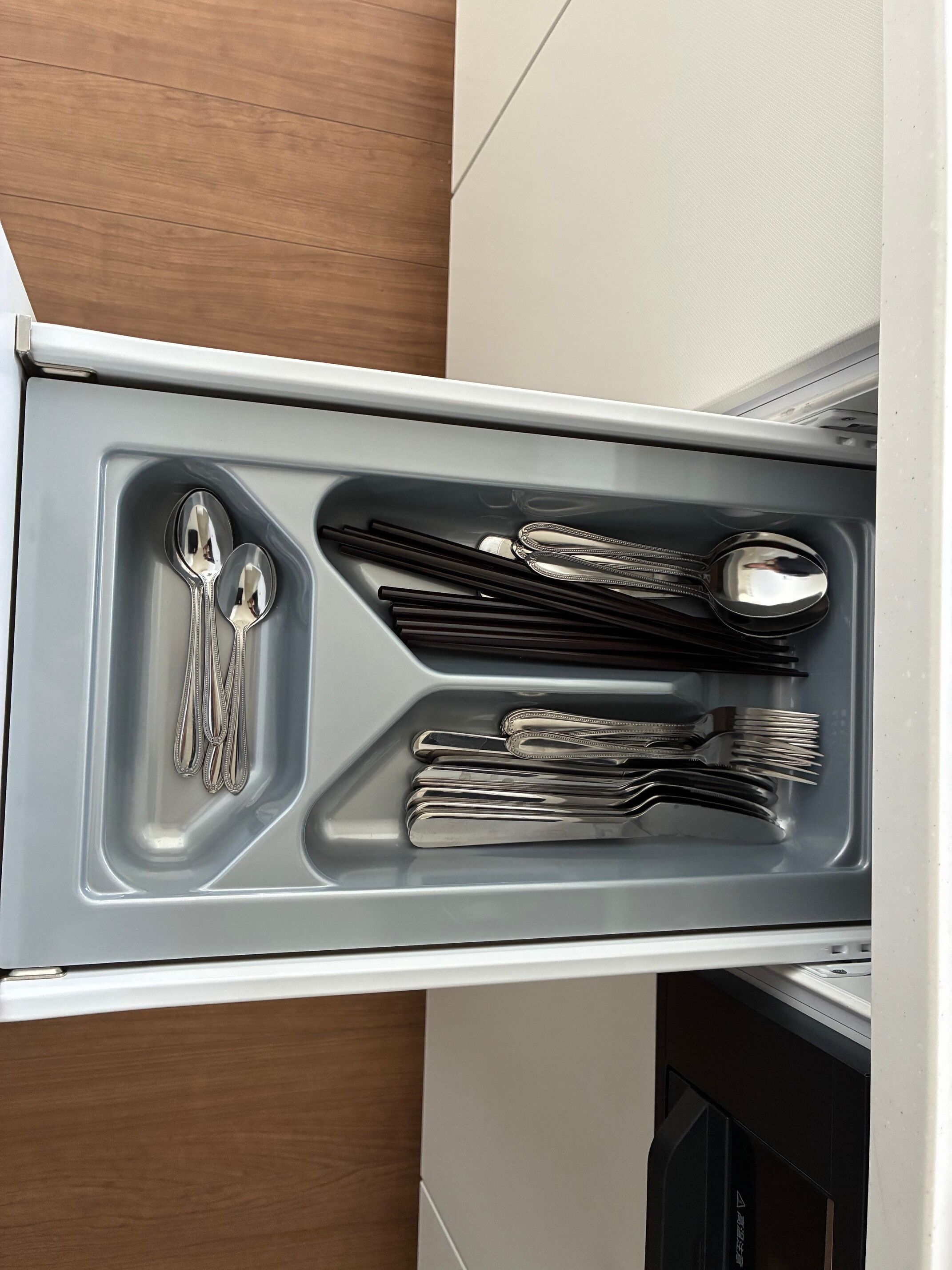 A kitchen drawer with utensils and cookware.