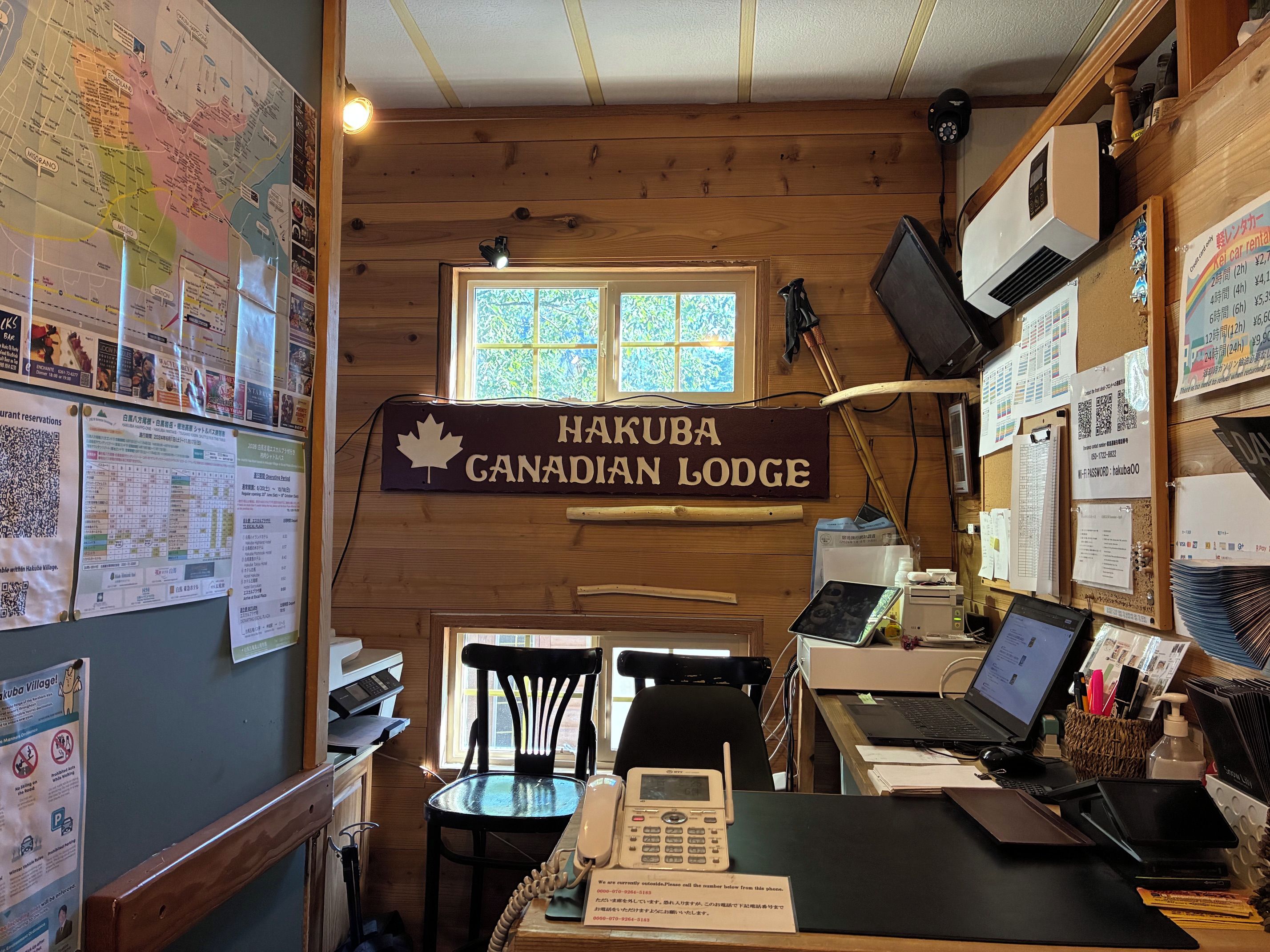 L'intérieur d'une cabine, avec un revêtement mural en bois, un bureau avec un ordinateur, une chaise et une fenêtre.