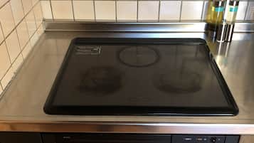 Cozinha com fogão preto, lava-louças e painel de azulejos.