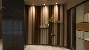Ein modernes Interieur mit einer Wand aus Holzleisten, einer schwarzen Marmorplatte und einem gefliesten Boden.