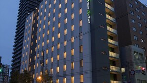 Ein mehrstöckiges Hotel mit moderner Fassade, großen Fenstern und einem markanten Eingang.