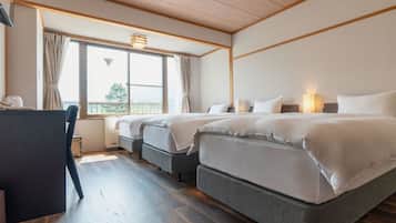 Habitación de hotel con dos camas, un escritorio y ventana con cortinas.