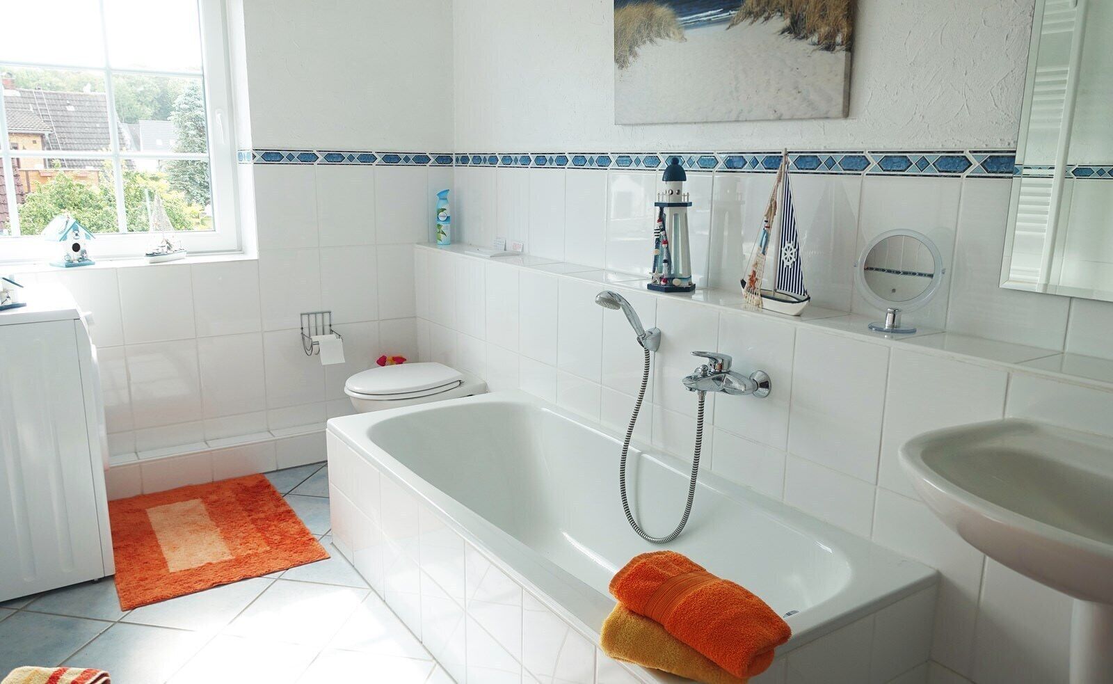 Ein Badezimmer mit Badewanne, Toilette, Waschbecken und einem Fenster mit Aussicht.