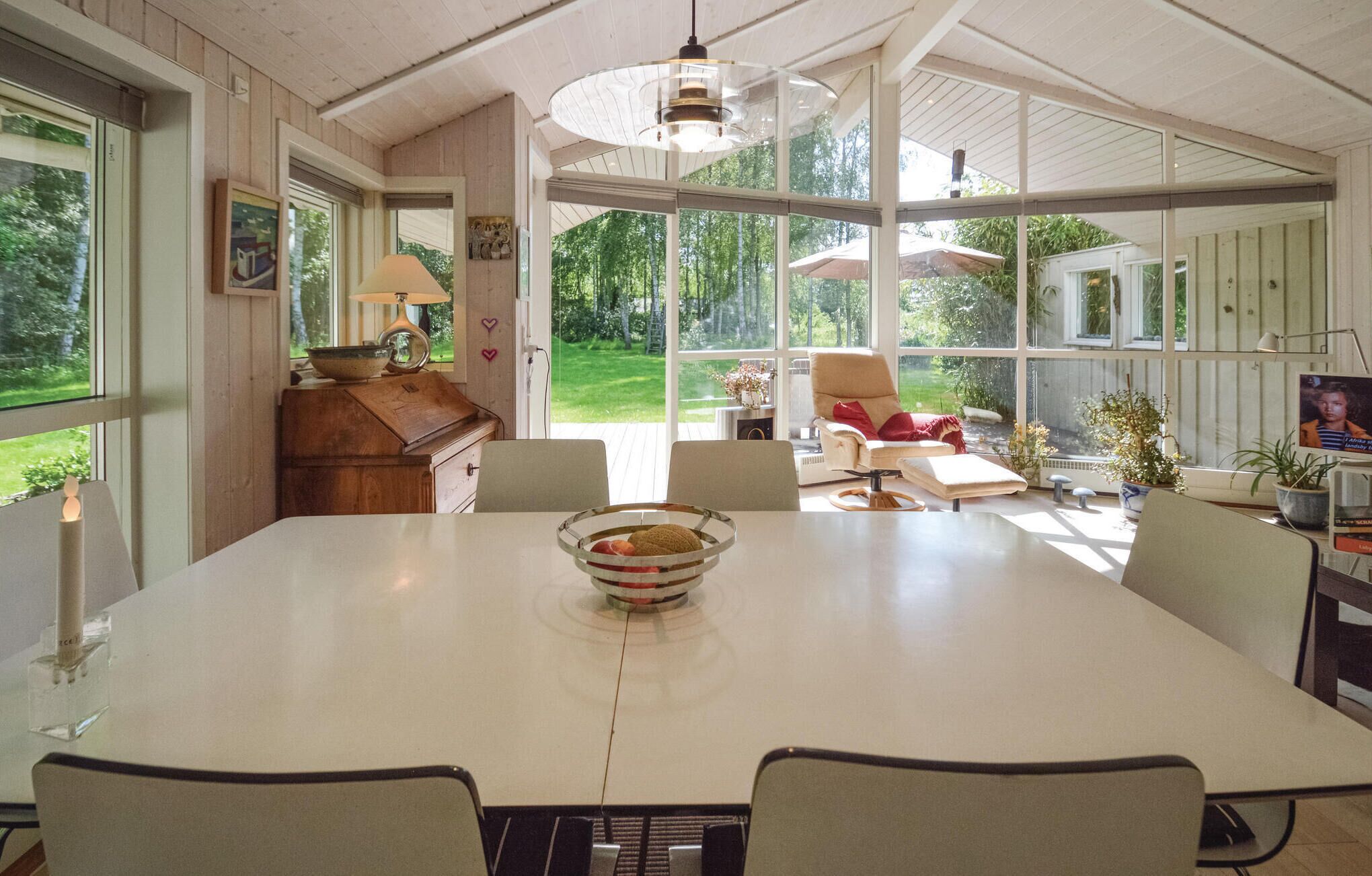 A spacious dining area with a large table, chairs, and a view of the outdoors.