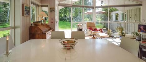 A spacious dining area with a large table, chairs, and a view of the outdoors.