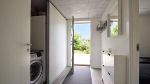 A laundry room with a washing machine, a dryer, and a door leading to a garden. - Lovely home in Juelsminde with WiFi (Juelsminde)