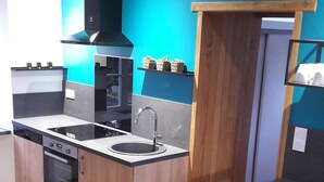 Uma cozinha moderna com armários de madeira, fogão preto e uma pia.