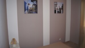 A room with two framed pictures on the wall, a lamp, and a small table. - Furnished holiday home with garden (Gujan-Mestras)