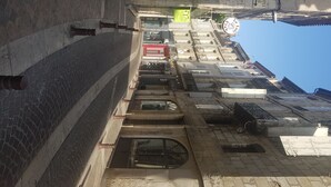 Eine enge Straße mit Häusern an beiden Seiten, darunter sowohl Geschäfte als auch Wohnhäuser.