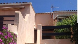A beige building with a staircase leading to a dark entrance. - Little Villa "La Maredda" in Porticcio with sea view terrace and beach at 250m! (Porticcio-Grosseto-Prugna)