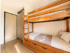 A bunk bed with a wooden frame and a mattress with a deer pattern.