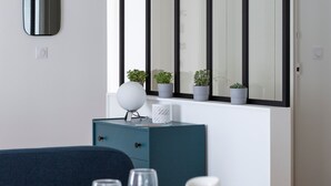 Ein moderner Essbereich mit einem weißen Tisch für vier Personen, einem blauen Schrank und einem großen Spiegel darüber.