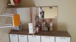 Una kitchenette con cubierta blanca, una silla y armarios debajo.