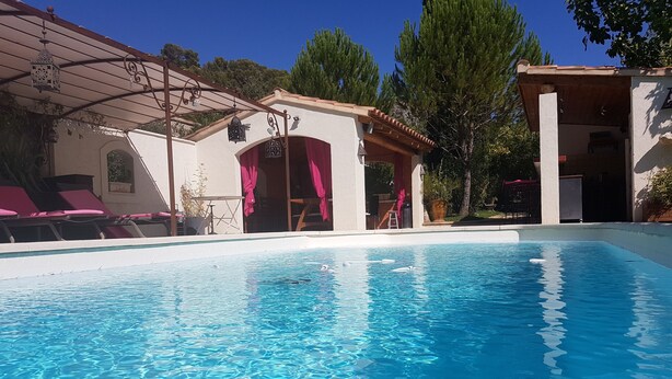 A clear blue swimming pool with lounge chairs and a covered patio area. - La Campanette in Luberon, private pool. (Cheval Blanc)