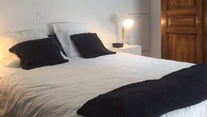 Un dormitorio con cama, mesita de noche, lámpara, armario y tragaluz.
