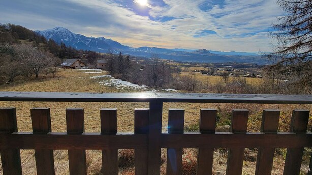 A wooden fence with a view of a mountainous landscape, including snow-capped peaks and a clear sky. - Spacious studio for 4 with balcony in Saint-Michel-de-Chaillol (Saint-Michel-de-Chaillol)