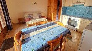A compact kitchen with a dining area, wooden ceiling, and a small table with chairs. - Spacious studio for 4 with balcony in Saint-Michel-de-Chaillol (Saint-Michel-de-Chaillol)