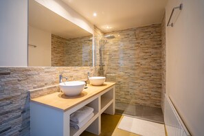 Een bad/douchecombinatie, een haardroger, toiletpapier