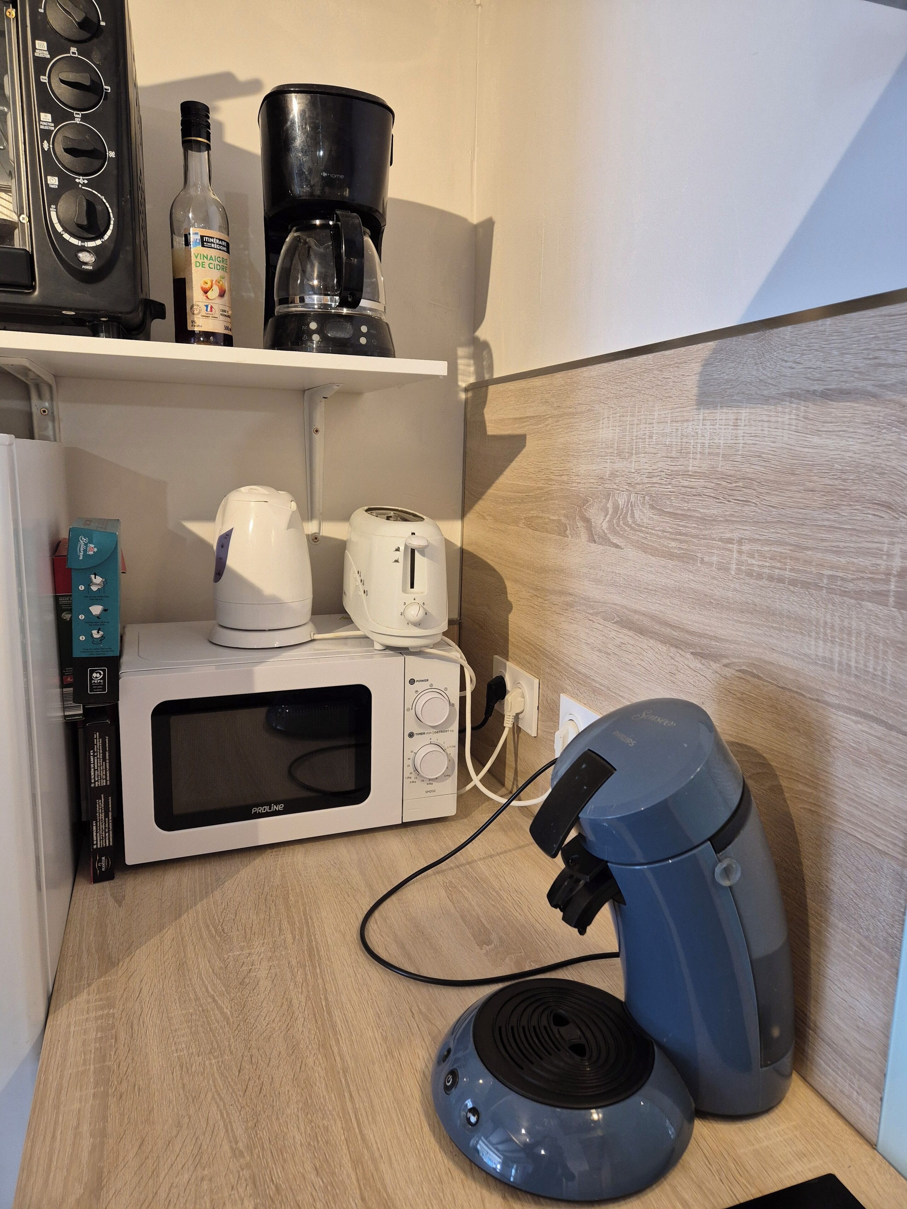 Une petite cuisine équipée d’un four à micro-ondes, d’un grille-pain, d’une bouilloire, d’une machine à café et d’un mixeur.