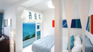 Un dormitorio con una cama grande, vistas al mar y un balcón.