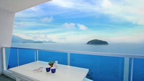 Varanda com vista para o mar e uma ilha ao longe.
