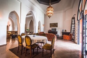 Cozy dining area with a round table and four chairs, a fireplace, and a large window.