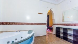 Une salle de bain moderne avec une grande baignoire, un meuble-lavabo avec un miroir et un carrelage décoratif.