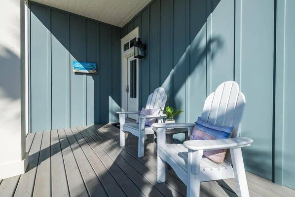 A porch with two white Adirondack chairs, a small table, and a potted plant. - Heated Private Pool*, Walk to the Beach! Golf Cart & 6 Bikes! - Blue Dune 30A in Blue Mountain Beach (Santa Rosa Beach)