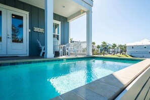 A swimming pool with a covered patio area, a door, and a view of neighboring houses. - Heated Private Pool*, Walk to the Beach! Golf Cart & 6 Bikes! - Blue Dune 30A in Blue Mountain Beach (Santa Rosa Beach)