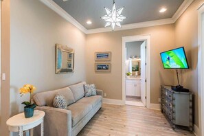 A living room with a sofa, a TV, and a star-shaped ceiling light. - Heated Private Pool*, Walk to the Beach! Golf Cart & 6 Bikes! - Blue Dune 30A in Blue Mountain Beach (Santa Rosa Beach)
