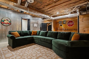 A cozy room with a sectional sofa, a sign with a moose and beer logo, and a stop sign on the wall. - Boat Days Begin Here, Walk to  Hurricane Marina (silver point)