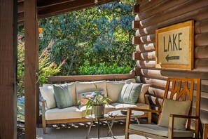 Una cabaña de madera con sofá y sillones, una mesita y un letrero que indica 'LAKE CENTER HILL'.