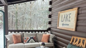 En træterrasse med en sofa, en gyngestol og et lille bord. Et skilt på væggen siger 'LAKE CENTER HILL'.