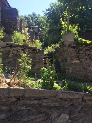 Situated amidst lush vegetation, this historic structure features irregular stone walls and terraces.