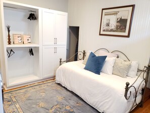 A bedroom with a bed, a wardrobe, a framed picture on the wall, and a decorative rug. - Downtown, 2 Parking spaces, Historic Beauty (Richmond)