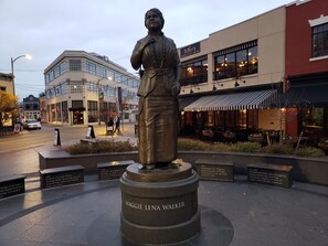 A statue of Maggie Lena Walker in a public square with informational plaques, surrounded by buildings and a street. - Downtown, 2 Parking spaces, Historic Beauty (Richmond)