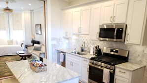 A modern kitchen with white cabinets, stainless steel appliances, and a marble countertop. - Downtown, 2 Parking spaces, Historic Beauty (Richmond)
