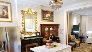 A modern kitchen with a marble island, stainless steel appliances, a fireplace, and a dining area with a chandelier. - Downtown, 2 Parking spaces, Historic Beauty (Richmond)