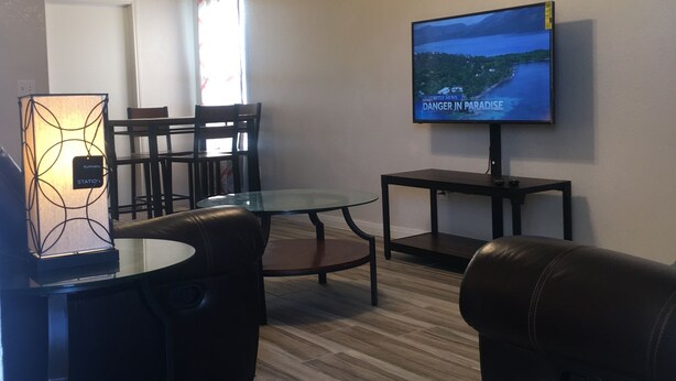 A living room with a dining area, a ceiling fan, a television, and a lamp. - DENIS TEMPORARY HOUSING 3 BEDROOMS APT- D (Killeen)