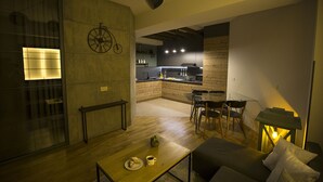 Un espace de vie moderne comprenant une cuisine, un coin repas et un salon confortable avec une table basse.