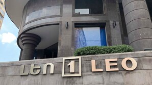 Un bâtiment sur lequel on peut lire l’inscription « Ltn LEO », doté d’une architecture moderne avec une façade incurvée et de grandes fenêtres.