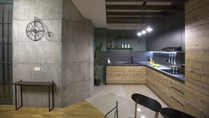Une cuisine moderne avec un mur d’accent en béton, des armoires en bois et une décoration sur le thème du vélo.